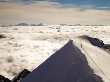 bulutlar bir denizin üzerinde yüksek bir tepe zirvesine yaklaştığını iki dağcılar