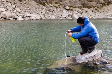 erkek dağcı Cordillera Blanca Peru Andes içinde yüksek ve uzak ana kamp turkuaz bir gölde içme suyu filtreleri