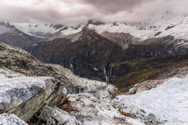 bir buzul ve kayaların ön planda kötü havada Peru Andes dağ manzarası
