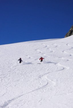 erkek ve dişi backcountry kayakçı Alpleri'nde taze toz karda ilk parça çizmek