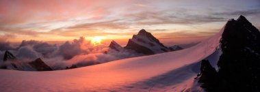 panoramic view of gorgeous pink sunrise over glacier and high mountain peaks in the Alps clipart