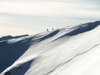 derin kışın uzun dağ sırtı Klosters İsviçre Alpleri'nde yakınındaki zirveye doğru üzerinde hiking iki backcountry kayakçı