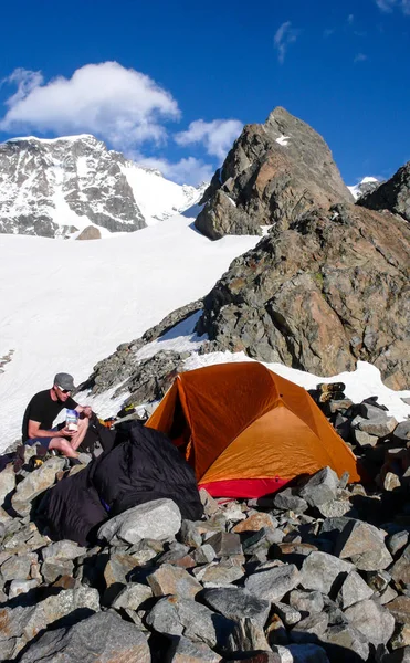 Male Mountain Climber Eating Base Camp Orange Tent Spectacular Mountain — Stock Photo, Image