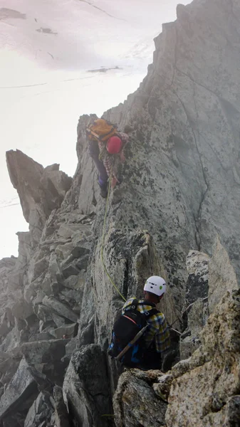 山区导游和客户前往一个雾天高山高峰峰会 — 图库照片