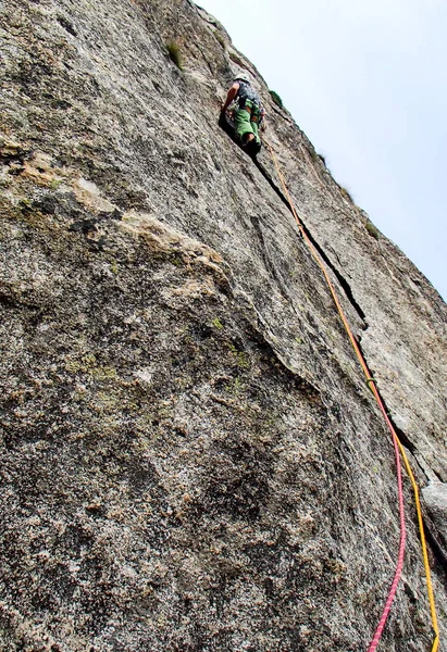 在瑞士瓦尔 Bregaglia 的花岗岩墙上 一条坚硬陡峭的登山路线上的男攀岩者 — 图库照片