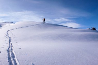 derin kışın uzun dağ sırtı Klosters İsviçre Alpleri'nde yakınındaki zirveye doğru üzerinde hiking bir erkek backcountry kayakçı