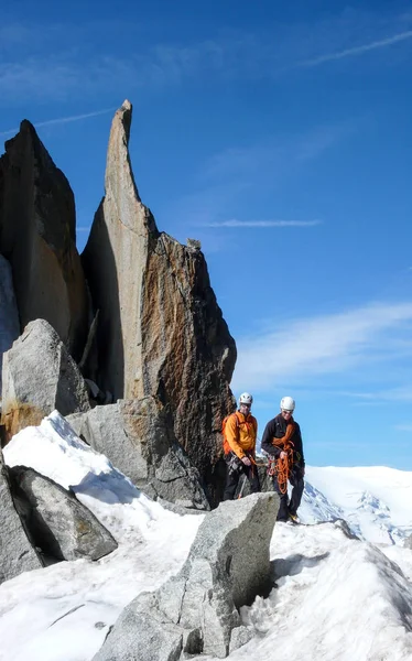 mountain guide and a male client on a rocky ridge heading towards a high summit in the French Alps near Chamonix