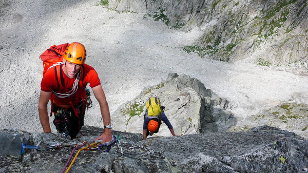 два альпиниста-скалолаза на гранитном маршруте в высокогорных вершинах юго-восточной Швейцарии
