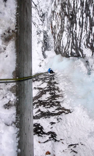 Male Ice Climber Blue Jacket Rappelling Bridge Railing Vertical Frozen — Stock Photo, Image