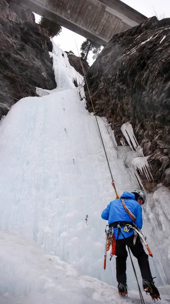 Hombre Escalador Hielo Una Chaqueta Azul Rappel Una Cascada Congelada —  Fotos de Stock