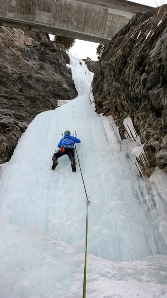 Hombre Escalador Hielo Una Chaqueta Azul Sube Una Cascada Congelada —  Fotos de Stock