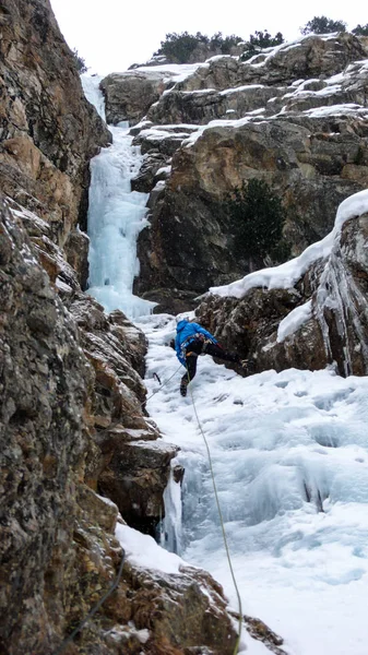 Escalador Gelo Masculino Uma Jaqueta Azul Uma Cachoeira Gelada Gorgrous — Fotografia de Stock