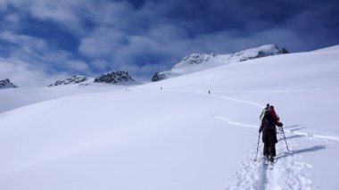 bir tur Avusturya Alpleri'nde ve zirveye doğru yola yeni parça koyarak iki backcountry kayakçı