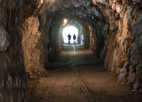 暗いトンネルを終了して入力を超えて光の二人のシルエット — ストック写真