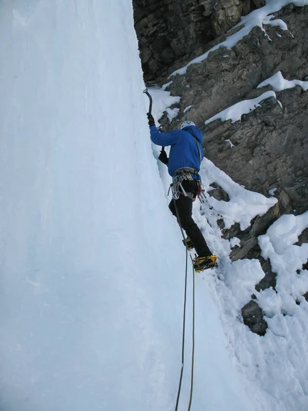 male ice climber ice climbing in Switzerland