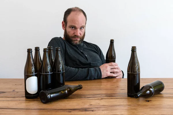 Middle Aged Alcoholic Man Many Beer Bottles Sitting Wooden Table — Stock Photo, Image