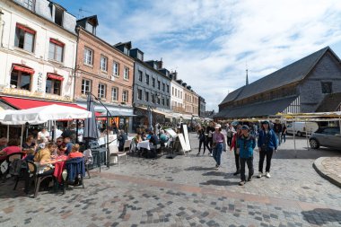 İnsanlar Honfleur köyünde güzel bir yaz gününün tadını çıkarıyorlar.