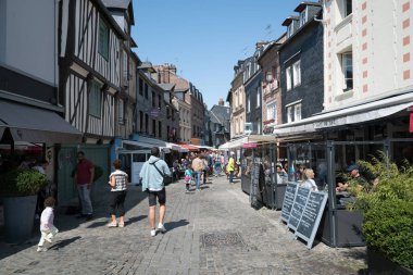İnsanlar Honfleur köyünde güzel bir yaz gününün tadını çıkarıyorlar.