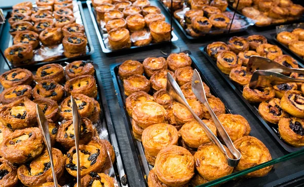 Heerlijke typische Bretonse kouignette taarten in verschillende stijlen in een bakkerij — Stockfoto