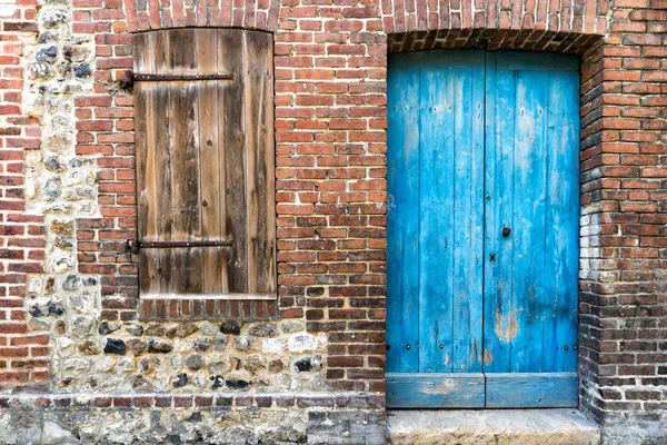 Detalle arquitectónico de una antigua casa de ladrillo y piedra con puerta colorida y obturador de madera — Foto de Stock