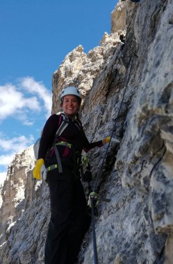 Çekici esmer kadın tırmanıcı dik bir yolda ve Via Ferrata 'da açıkta.