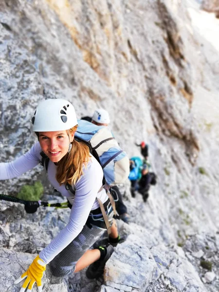 Attractive blonde female mountain climber on a steep Via Ferrata — Stock Photo, Image