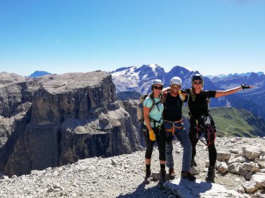 mountain guide and two female climbers celebrate standing on the clipart