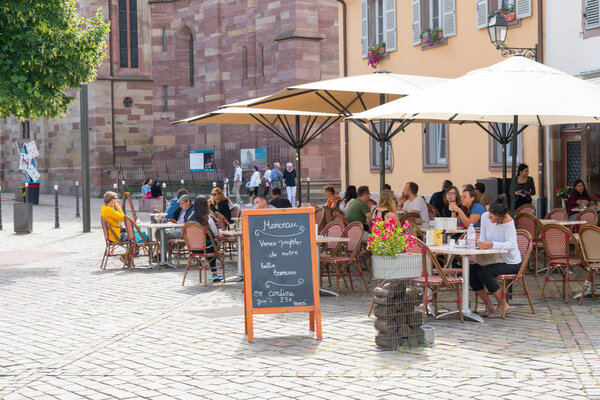 people enjoying drinks in French cafe outside of Saint Thomas' Church