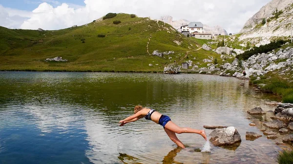 Attractive blonde in her twenties diving into a mountain lake — Stock Photo, Image