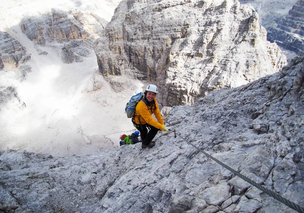 attractive mountain climber on a steep and hard Via Ferrata climb