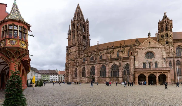 Freiburg 'daki katedrali ve papazı ziyaret eden turistlerin manzarası 