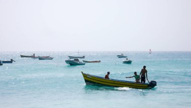 Afrikalı balıkçılar küçük ahşap bir kayığı tropik bir B 'den fırlatıyorlar.
