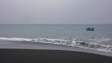 Afrikalı balıkçı, tahtadan bir kayıkla siyah lav sa 'da balık tutuyor.