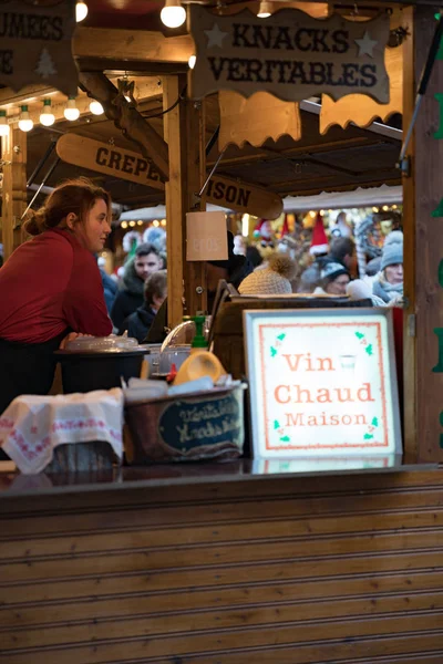 Vrouw op een drukke marktkraam met glühwein en eten — Stockfoto