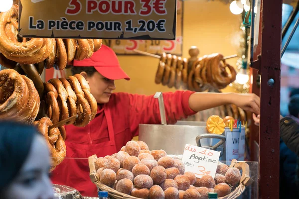 Vrouw die heerlijke verse pretzels verkoopt van een marktkraam — Stockfoto