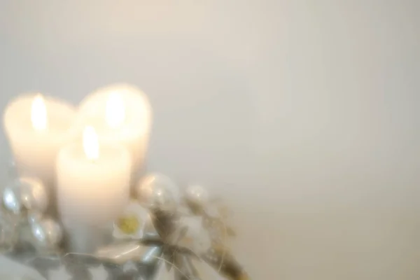 Белые свечи и яркий рождественский венок с безделушками и деокрацией классический мягкий фокус выглядят с копировальным пространством — стоковое фото