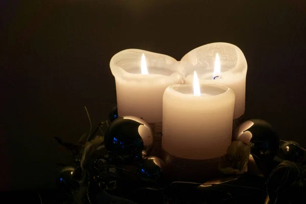 Brennende weiße Kerzen und silbrig glänzende Christbaumkugeln de — Stockfoto