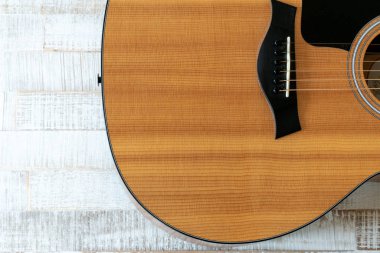 Beyaz bir ahşap üzerinde güzel bir akustik gitarın yukarıdan görünüşü