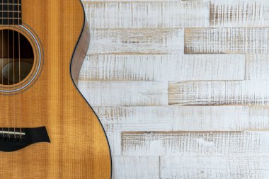 Beyaz bir ahşap üzerinde güzel bir akustik gitarın yukarıdan görünüşü