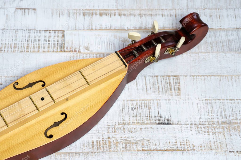 Appalachian mountain dulcimer musical instrument on a rustic whi