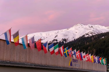 the congress center in Davos with flags of nations at sunrise du clipart