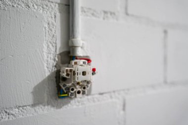 Parlak bir kiler odasında kısmen kurulu elektrik prizinin seçici odak noktası