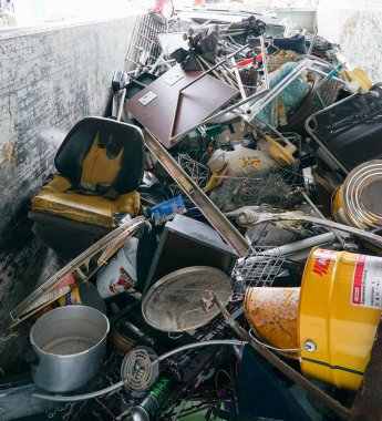 A close up view of large recycling bin filled with old steel and metal items