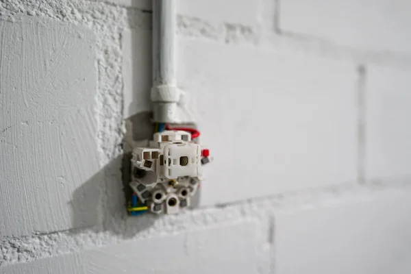 Selektive Nahaufnahme der teilweise installierten Steckdose für Strom in einem hellen Kellerraum — Stockfoto