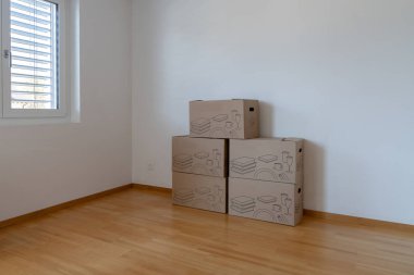 Boş bir apartman dairesinde büyük kahverengi taşınma ve paketleme kutularının yatay görünümü