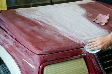 Boya yapmadan önce bir adamın el kaputunu zımparalarken yakın çekim görüntüsü.