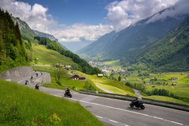 Linthtal, GL / İsviçre - 17 Mayıs 2020: Glarus yakınlarındaki İsviçre Alplerindeki Klausenpass dağ yolunda yarışan birçok motosikletin manzarası