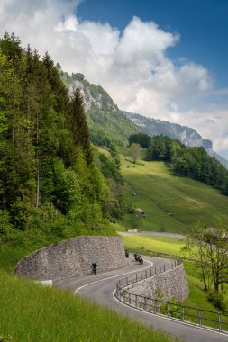 Linthtal, GL / İsviçre - 17 Mayıs 2020: İsviçre Alpleri 'ndeki eğri Klausenpass yolunun dikey görünümü Linthtal Alp köyünün yukarısındadır.