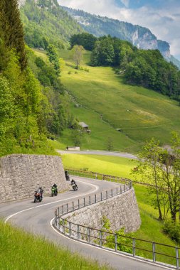 Linthtal, GL / İsviçre - 17 Mayıs 2020: İsviçre Alpleri 'ndeki eğri Klausenpass yolunun dikey görünümü Linthtal Alp köyünün yukarısındadır.