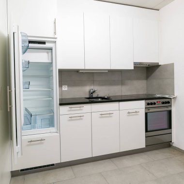 Gri beyaz ve siyah taştan yapılmış basit ve modern bir mutfak manzarası.